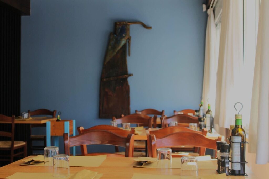 Sala con parete azzurra e tavoli apparecchiati