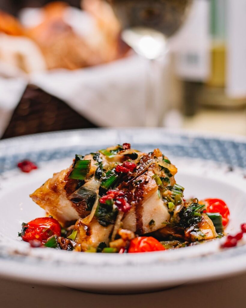 Piatto di pesce con pomodorini e verdure